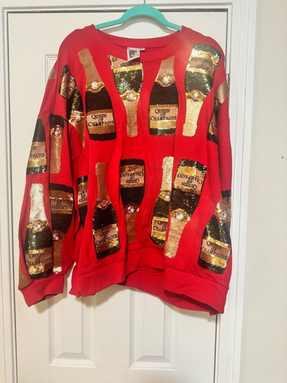 QUEEN OF SPARKLES Red Crewneck Sweater with Gold Champagne Bottle Print